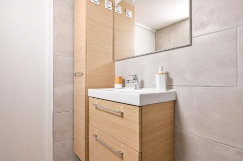 een badkamer met een wastafel en een spiegel bij Jolie appartement climatisé in La Ciotat