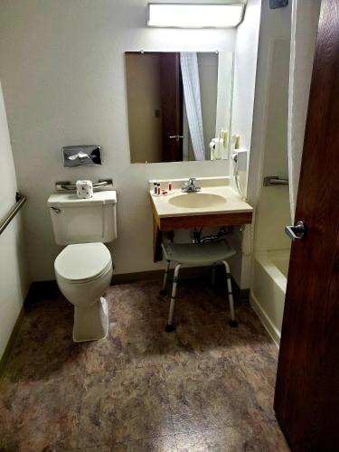 a bathroom with a toilet and a sink and a mirror at Super 8 by Wyndham Ticonderoga in Ticonderoga