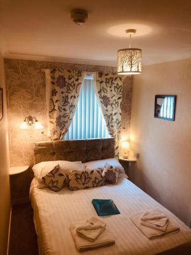 a bedroom with a bed with two towels on it at The Purple Tree Guest House in Torquay
