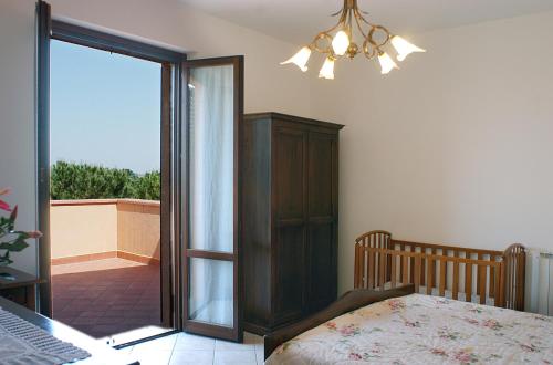 カスティリオーネ・デル・ラーゴにあるPoggio Bella Vistaのベッドルーム1室(ベッド1台付)、スライド式ガラスドアが備わります。