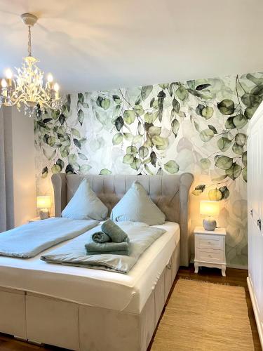 1 dormitorio con 1 cama con pared de flores en Moselblick Winningen Traumwohnung im „La Mosel“, en Winningen