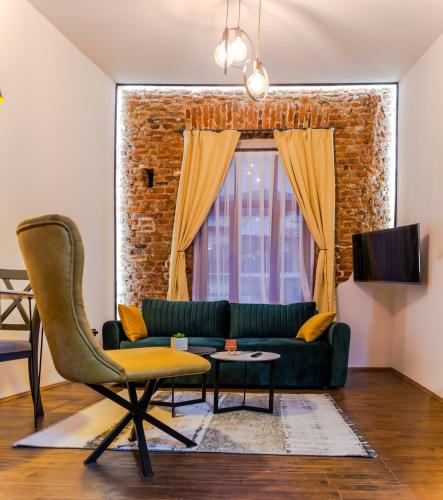 a living room with a green couch and a window at MariaApartments in Bitola
