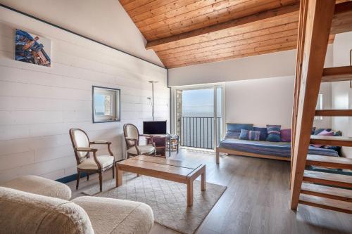 una sala de estar con un sofá y una mesa en Superbe vue Mer - Vacances à 5 personnes à Arzon, en Arzon