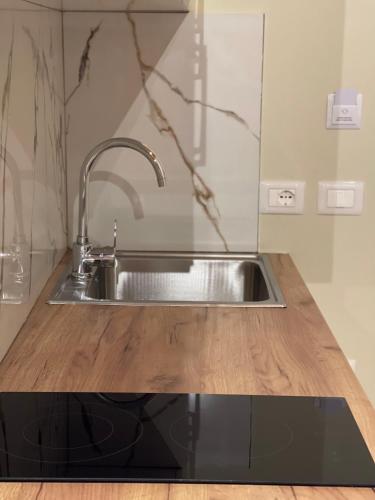 a kitchen sink with a wooden counter top at Arial Penthouse Suites in Vlorë