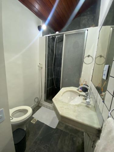 a bathroom with a sink and a toilet at Loft Praia dos Anjos in Arraial do Cabo