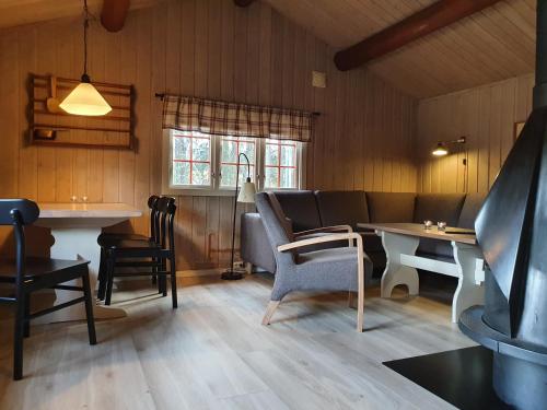 a restaurant with tables and chairs in a room at Groven Camping & Hyttegrend in Åmot