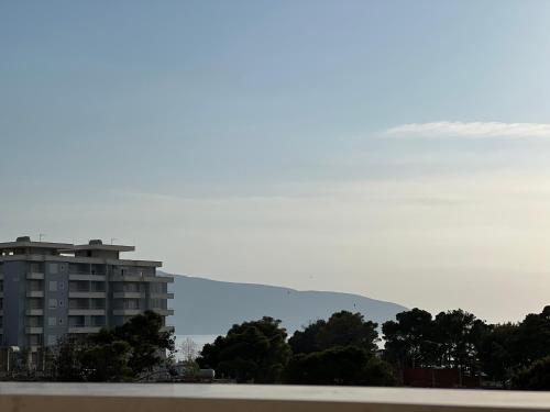 a view of a building and the ocean and a mountain at Arial Penthouse Suites in Vlorë