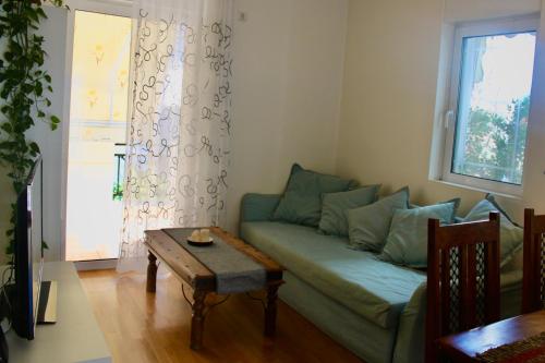 My Way Hotel في أثينا: غرفة معيشة مع أريكة خضراء وطاولة