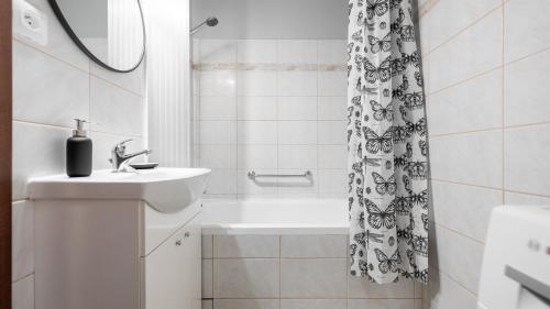 a bathroom with a sink and a shower curtain at Apartament - 3min od plaży - Chillout vibes in Gdańsk