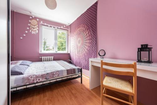 a bedroom with pink walls and a bed and a chair at Apartament - 3min od plaży - Chillout vibes in Gdańsk