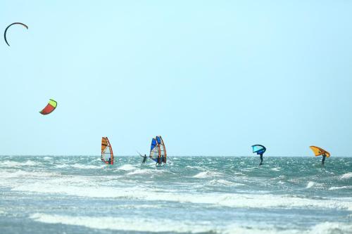 een groep mensen die windsurfen in de oceaan bij Vila Kalango in Jericoacoara