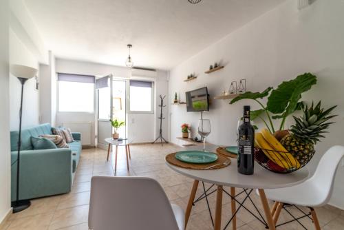 een woonkamer met een tafel met een fles wijn bij Central Apartment Next To The Beachfront in Heraklion