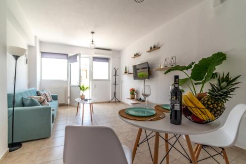 uma sala de estar com uma mesa e uma garrafa de vinho em Central Apartment Next To The Beachfront em Heraclião