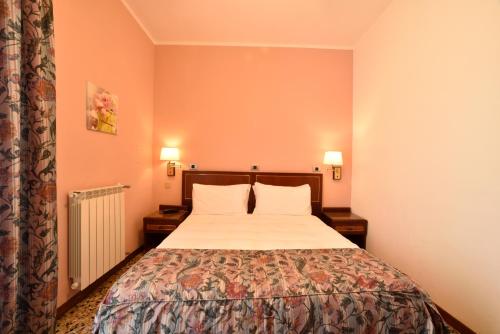a bedroom with a bed and two lamps and a curtain at Hotel Bergamo Mare Mhotelsgroup in San Bartolomeo al Mare