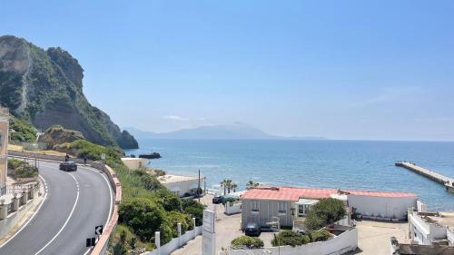 a winding road next to the ocean on a hill at Naro Suites and Rooms in Bacoli