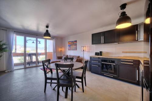 une cuisine et une salle à manger avec une table et des chaises dans l'établissement IMMOGROOM - Rénové - Loggia - Vue dégagée - Parking - Clim, à Cannes