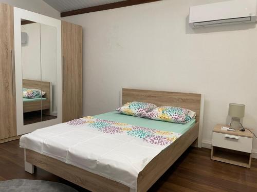 - une chambre avec un lit doté de draps blancs et d'oreillers colorés dans l'établissement SPACIEUX T5, à Kourou