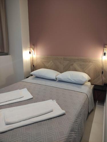 Un dormitorio con dos camas con toallas blancas encima. en Filema, en Preveza