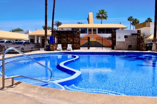 une grande piscine bleue en face d'un bâtiment dans l'établissement HOTEL POSADA DEL DESIERTO, à Heroica Caborca