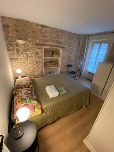 une chambre avec un lit et un mur en pierre dans l'établissement C054-Bel Appartement Lumineux au Coeur du Suquet, à Cannes