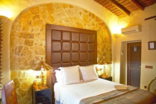 a bedroom with a bed and a stone wall at Casa Pinto in Monsaraz