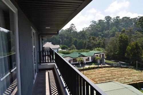 a balcony with a view of a house at The Edge Luxury Apartment in Nuwara Eliya