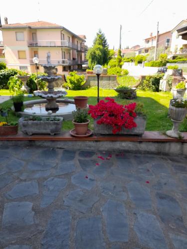 a garden with a fountain and some plants and flowers at La casa del Tiglio in Sarzana