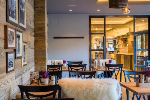 a restaurant with tables and chairs with fur at Hotel Bockelmann in Bispingen