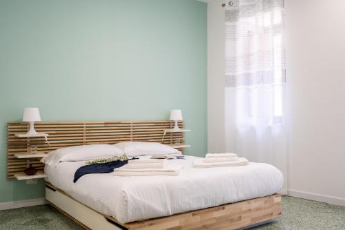 a bedroom with a large bed with a wooden headboard at Via Venezia 32 House in Petralia Sottana