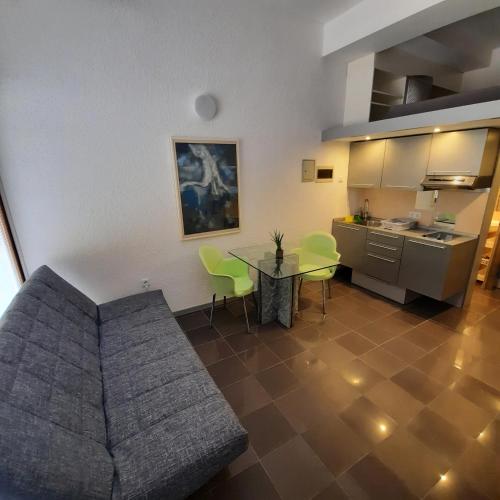 a living room with a couch and a table and a kitchen at Apartment Kristjan in Portorož