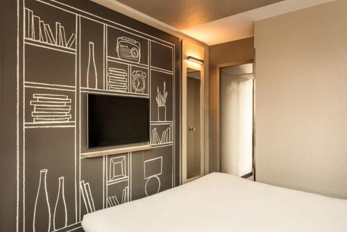 a bedroom with a chalkboard wall with a television at ibis Bordeaux Centre - Gare Saint-Jean in Bordeaux