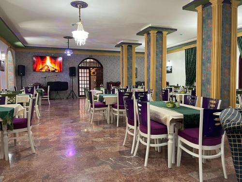 a restaurant with tables and chairs and a fireplace at Voila Inn Predeal in Predeal