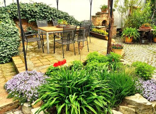 a patio with a table and chairs and flowers at Winzerhof Fleischmann in Kleinhöflein