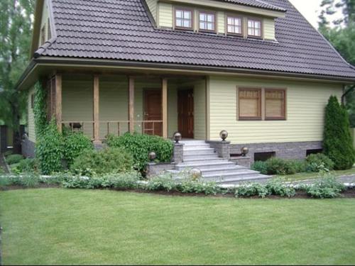 una casa con porche y escaleras en el patio en Tammehouse, en Otepää