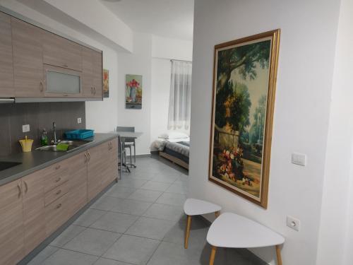 una cocina con una pintura colgada en la pared en Margaritas Apartments en Sarandë