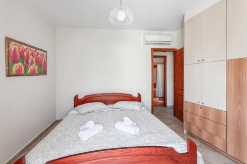 a bedroom with a bed with white shoes on it at Corfu Don Camillo Apartment in (( Agía Eleoúsa ))