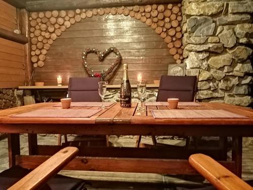 a wooden table with a bottle of wine and glasses at U Vodníka in Mohelnice