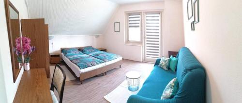 シオーフォクにあるTinka Házのリビングルーム(青いソファ、ベッド付)