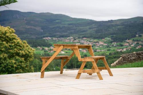 a wooden table and stool sitting on top of a table at Casa das Infusões - Soalheiro in Melgaço