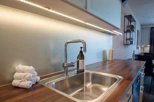 a kitchen sink with a bottle of wine on it at Central City Apartment in Sønderborg
