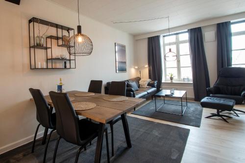 a living room with a wooden table and chairs at Central City Apartment in Sønderborg