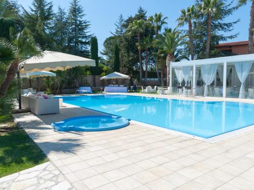 una piscina in un resort con palme di B&B Villa Adriana ad Andria