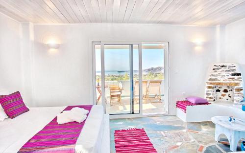 a bedroom with a bed and a view of the ocean at Aspra Chomata Villas in Karistos