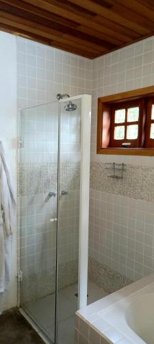a bathroom with a shower and a sink and a tub at CASA EM MONTE VERDE CHARME E CONFORTO in Monte Verde
