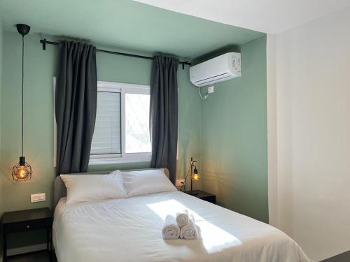 1 dormitorio con 1 cama con 2 zapatillas en Lovely New Central Apartment, en Beer Sheva