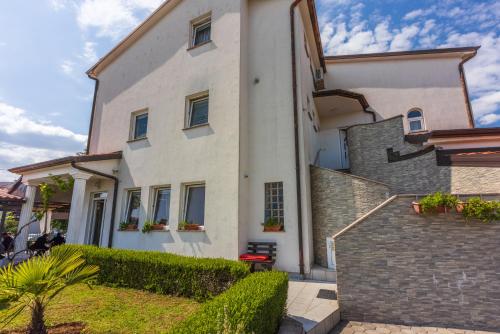 a white building with plants on the side of it at Apartments Villa Bare in Kastav