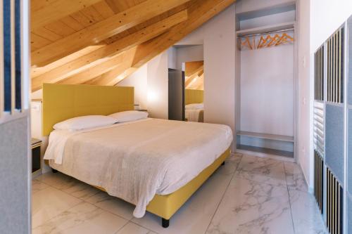 a bedroom with a large bed with a wooden ceiling at CASA KING in Como