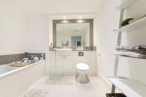 a white bathroom with a sink and a toilet at Panoramic Riverside Facing - 2 Bed - 2 Bath - 2 Balconies - London Nine Elms in London