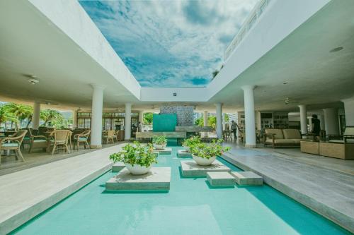 a pool in a house with a sky ceiling at Tamaca Beach Resort in Santa Marta