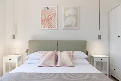 een slaapkamer met een bed met twee witte nachtkastjes bij Antheon apartments in Vathi